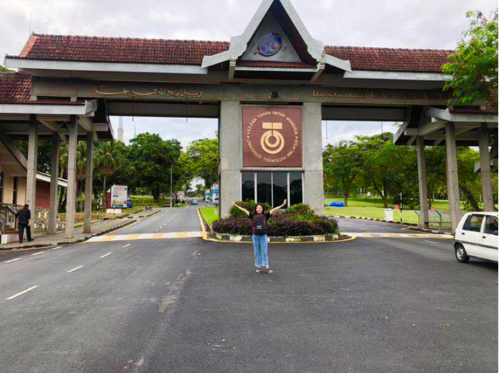 学生在马来西亚理工大校门口留影.png